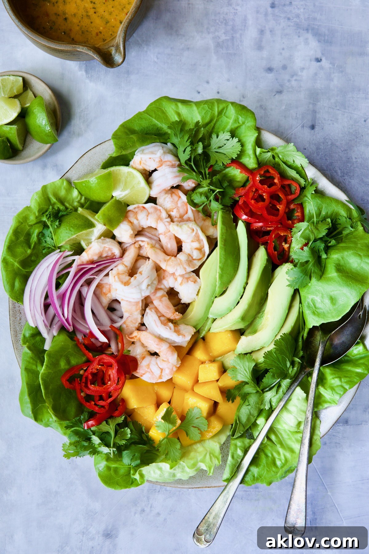 The fully assembled Butter Lettuce Salad with Shrimp, Mango, and Avocado, elegantly arranged on a platter with serving utensils, demonstrating the colorful and fresh appeal of the dish.