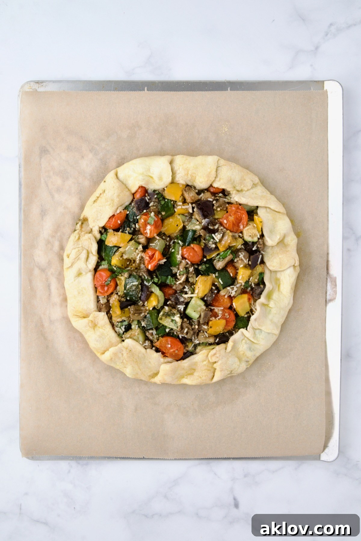 Fully assembled galette on parchment paper on cookie sheet before being baked.