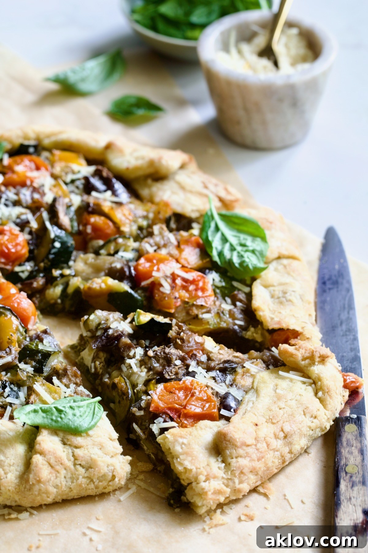 Two wedges of Mediterranean Vegetable Galette on parchment paper.