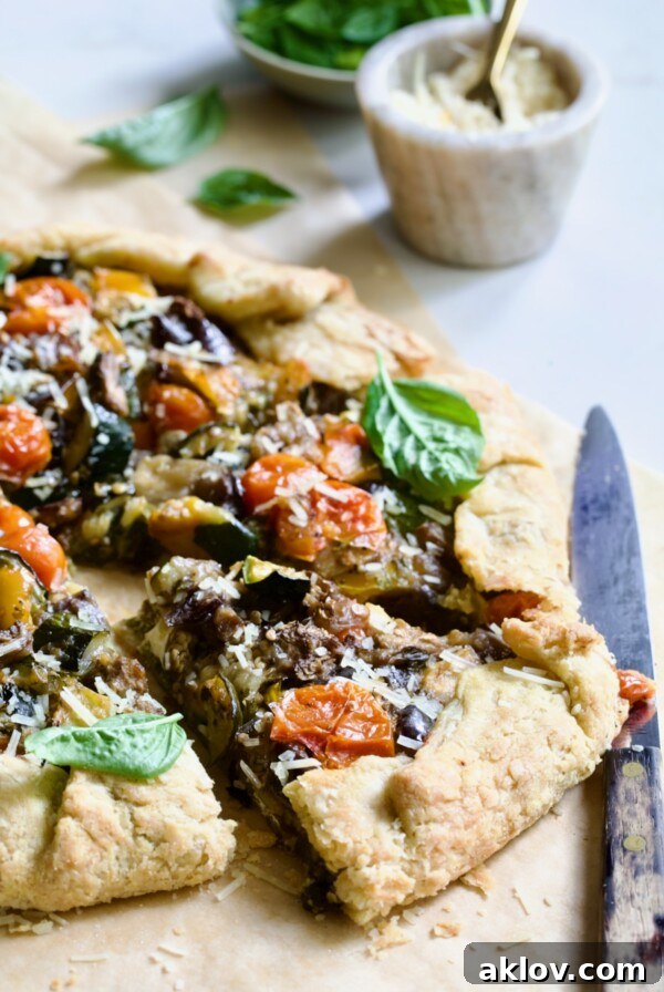 Two wedges of Mediterranean Vegetable Galette on parchment paper, perfect for a rustic meal.