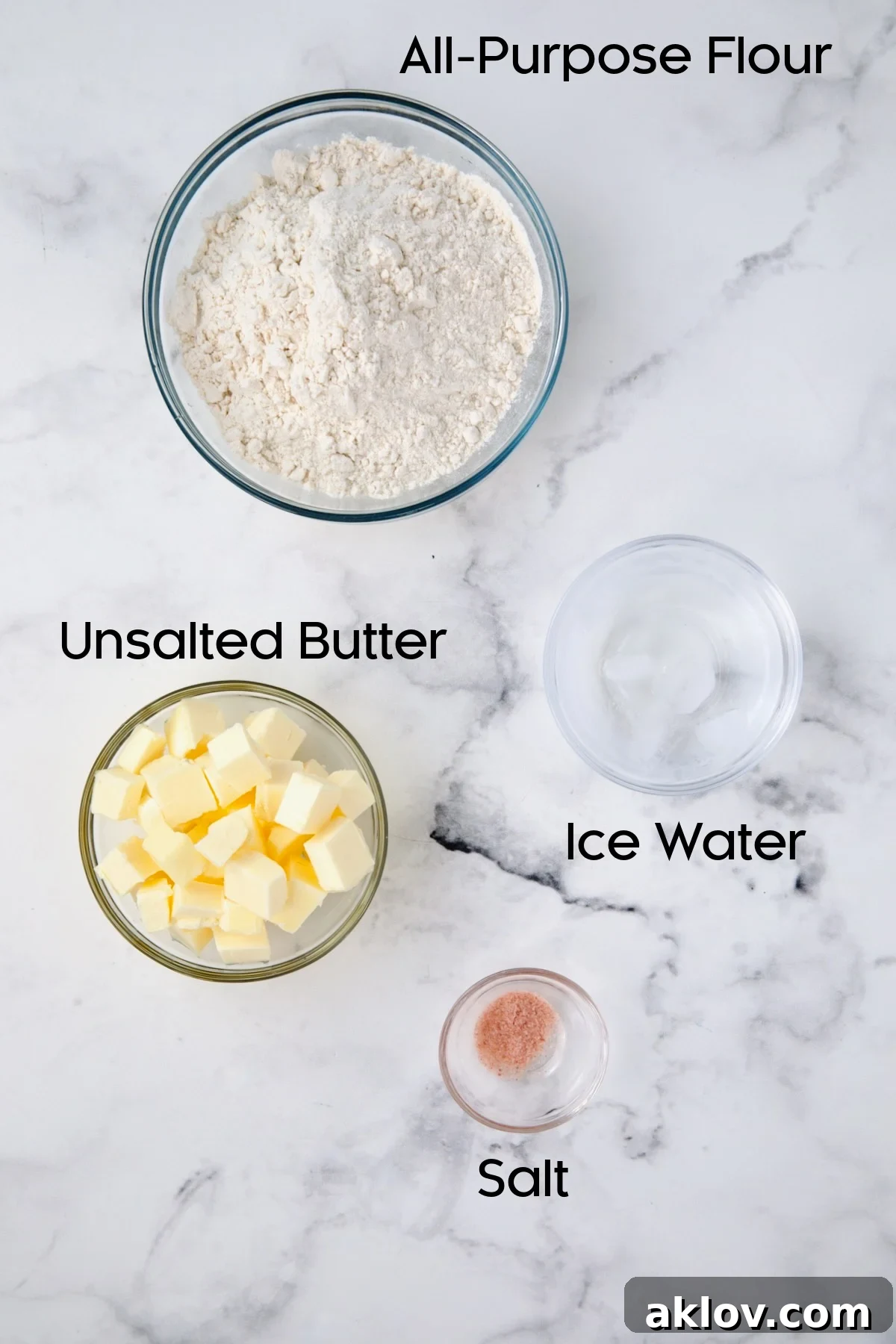 Glass bowls containing all-purpose flour, salt, and cubes of unsalted butter, ready for making galette pastry dough.