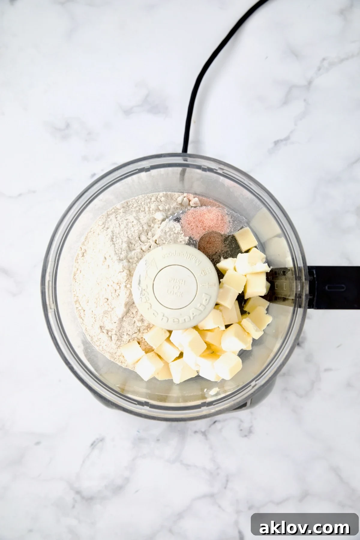 Flour, salt, and cold butter cubes in a food processor bowl before being pulsed for galette dough.