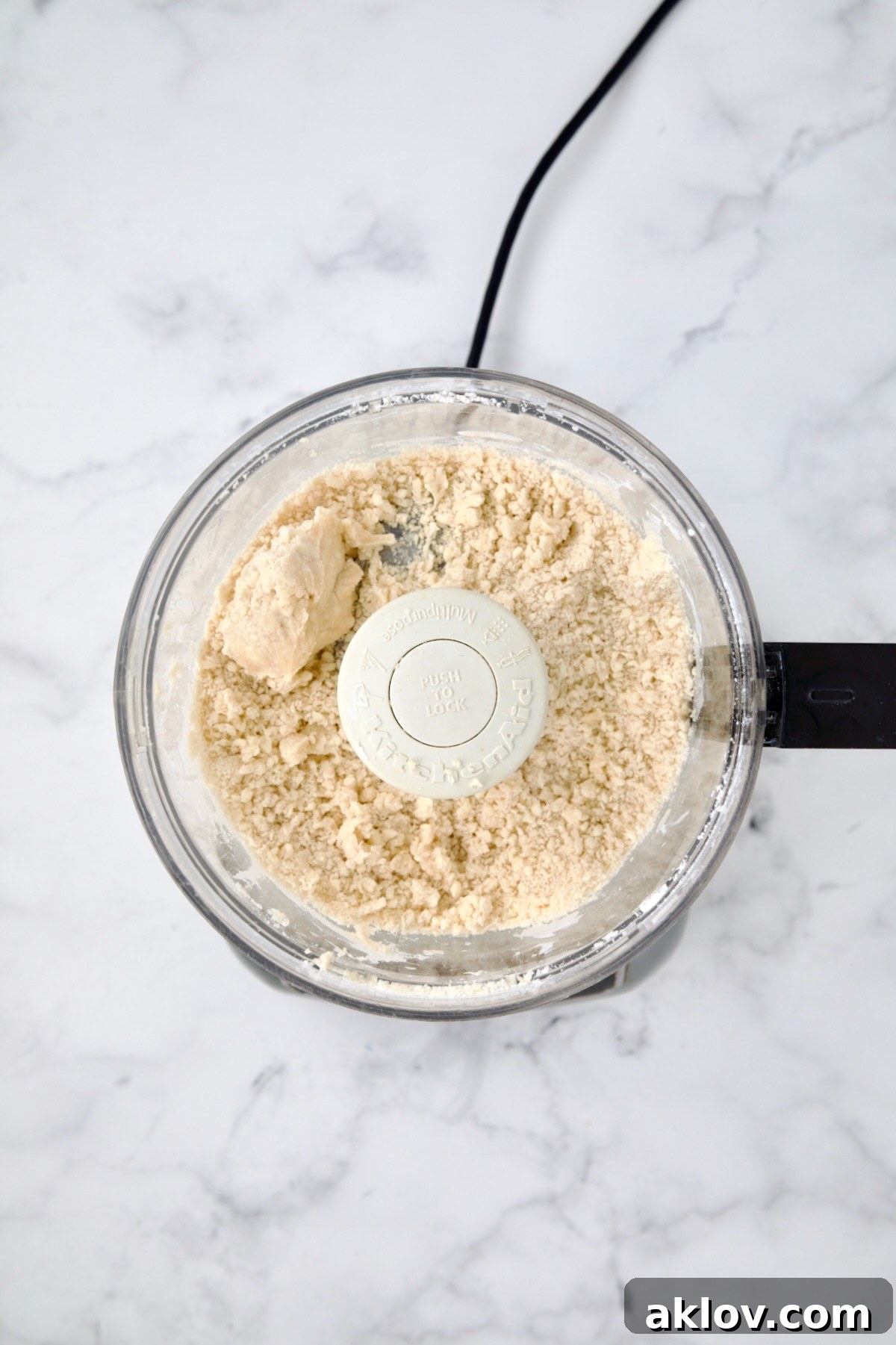 Ingredients for galette dough in food processor holding together after ice water is added.