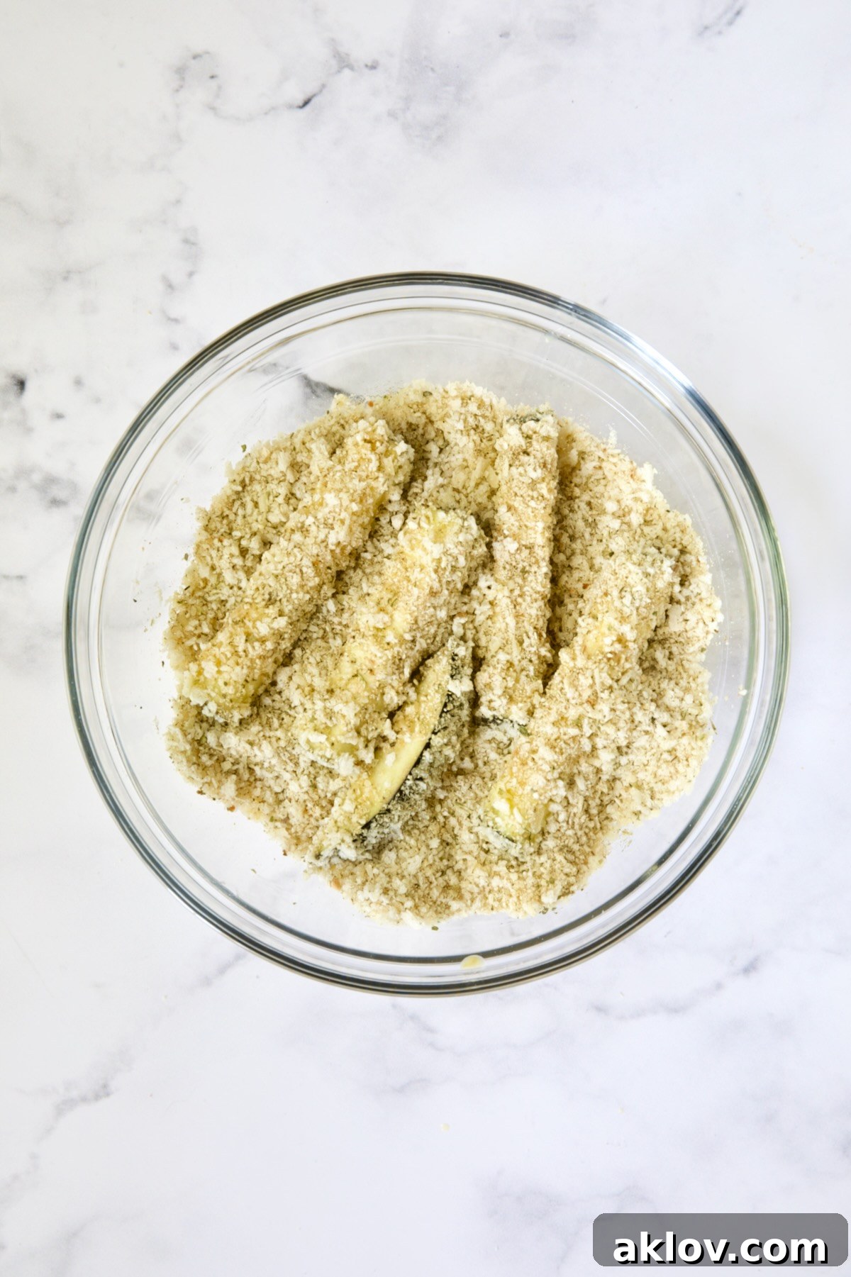 Eggplant fries in breadcrumb coating in glass bowl.