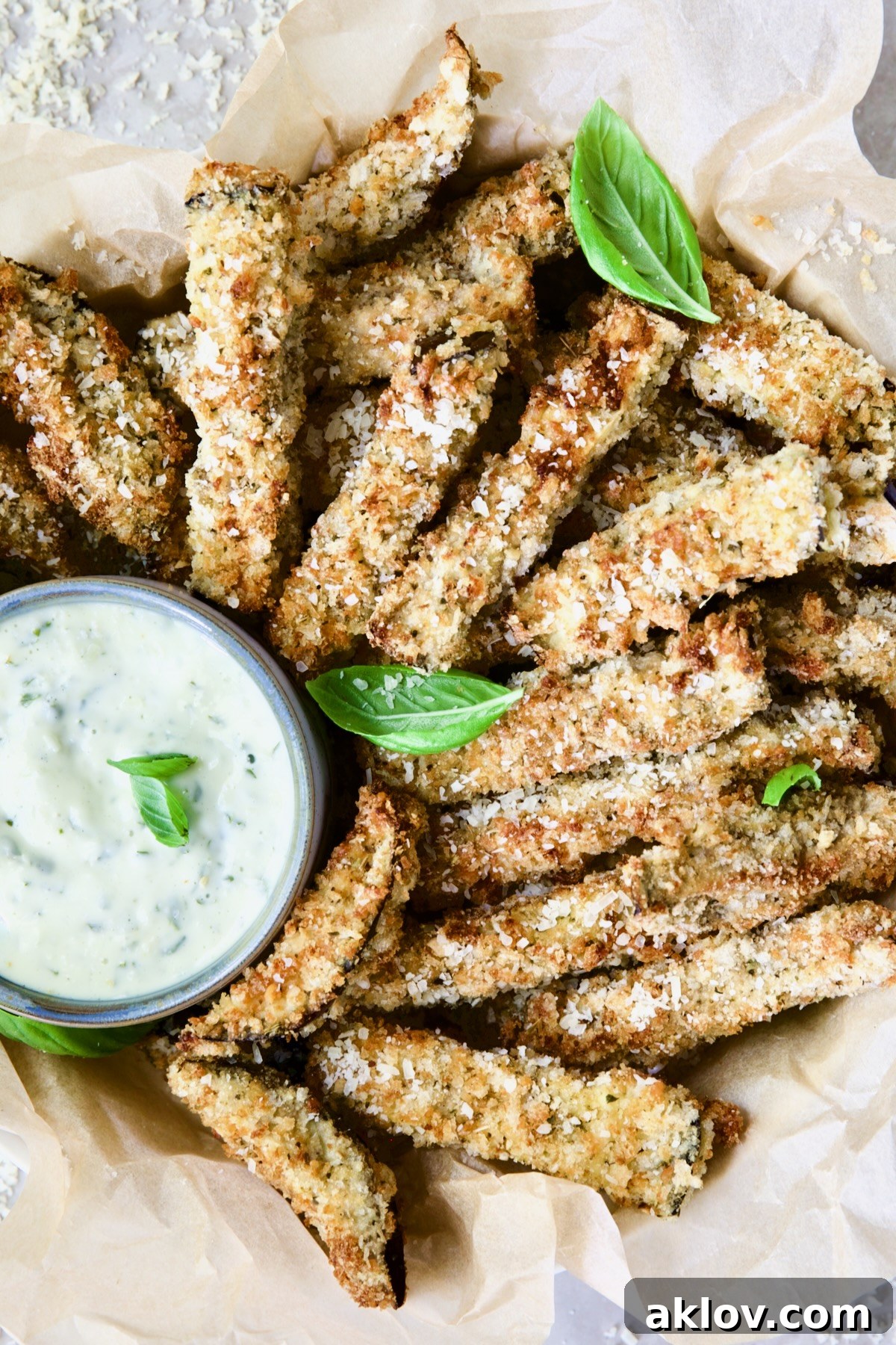 Air Fryer Eggplant Fries with Garlic Basil Aioli garnished with fresh basil.