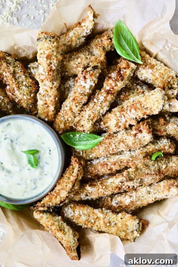 Air Fryer Eggplant Fries with Garlic Basil Aioli garnished with fresh basil.