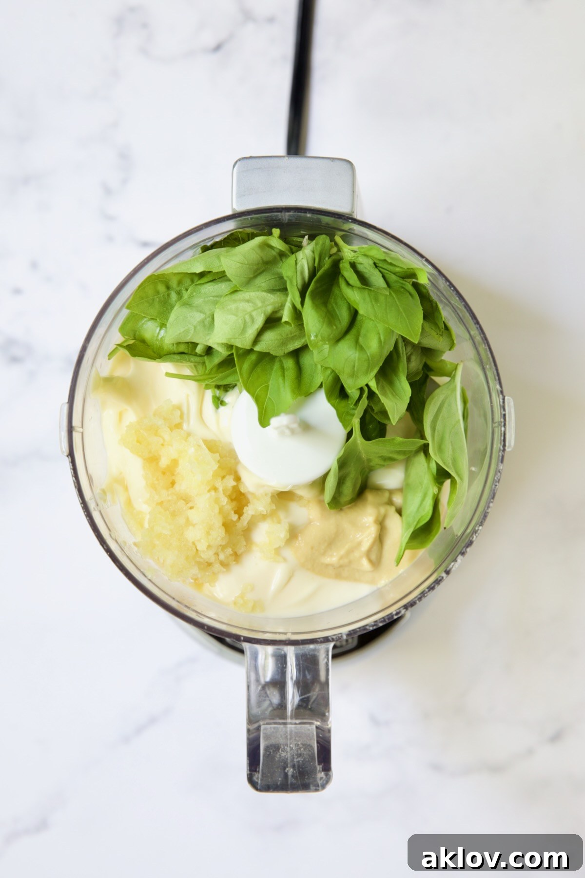 Ingredients for Garlic Basil Aioli in mini food processor.