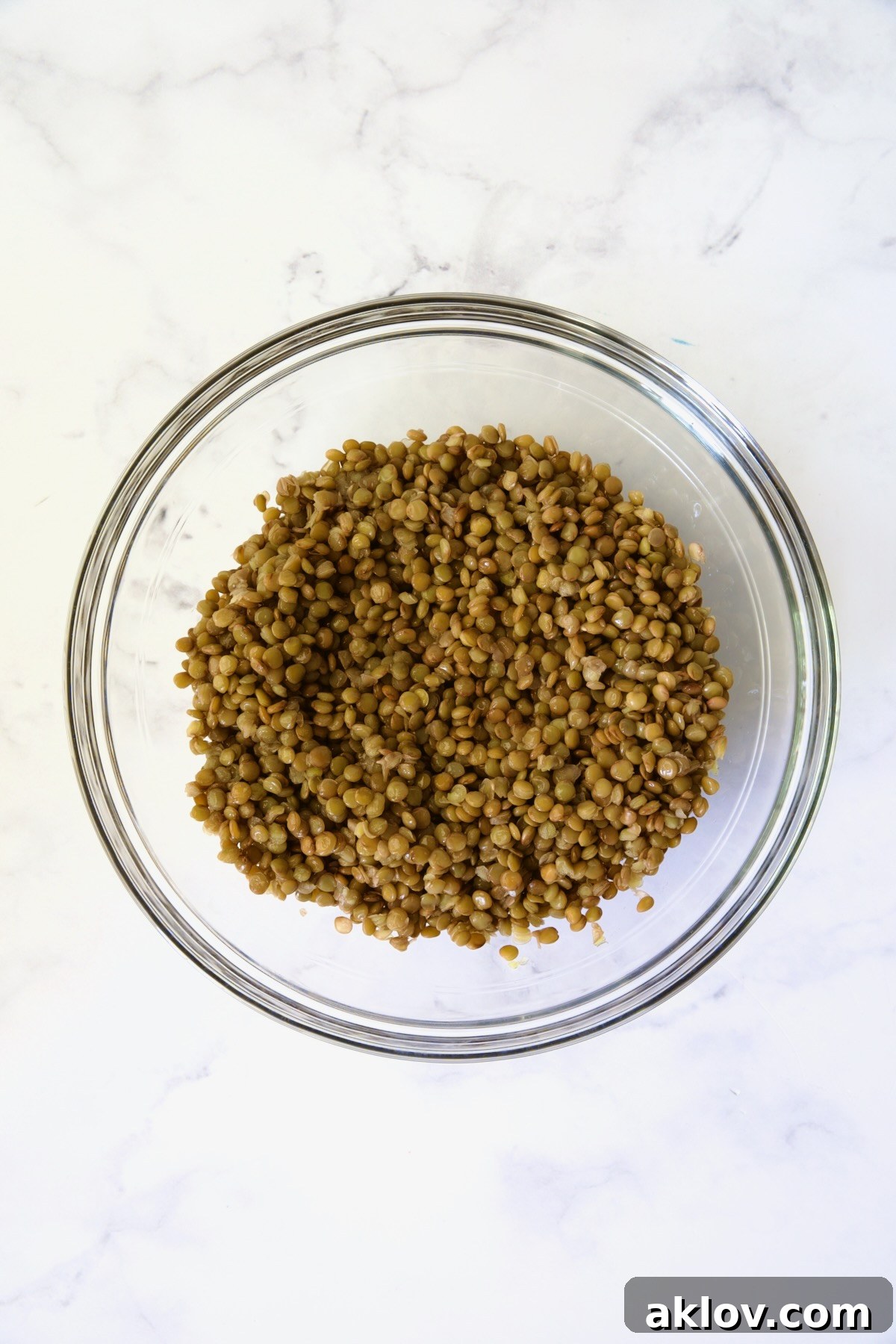 Cooked lentils in glass bowl.