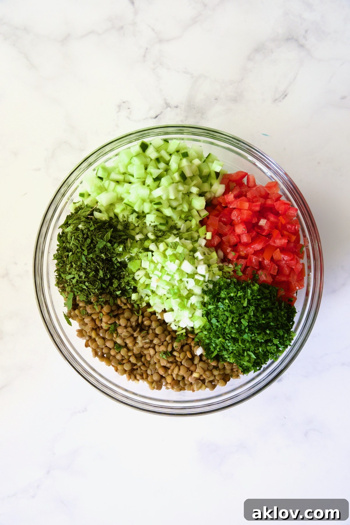 Ingredients for Lentil Tabbouleh in glass bowl before being mixed together.