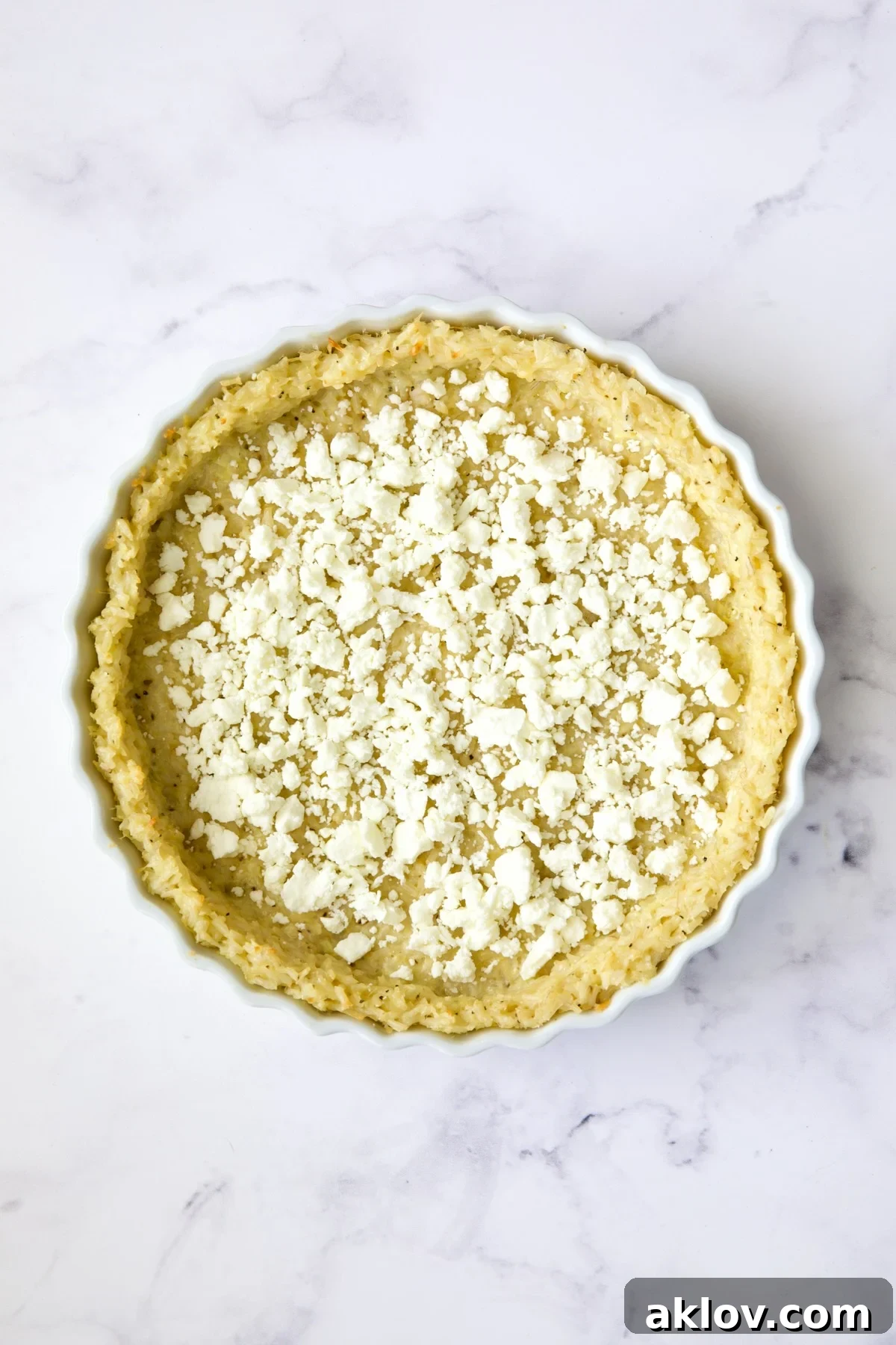 Feta cheese scattered over brown rice crust.