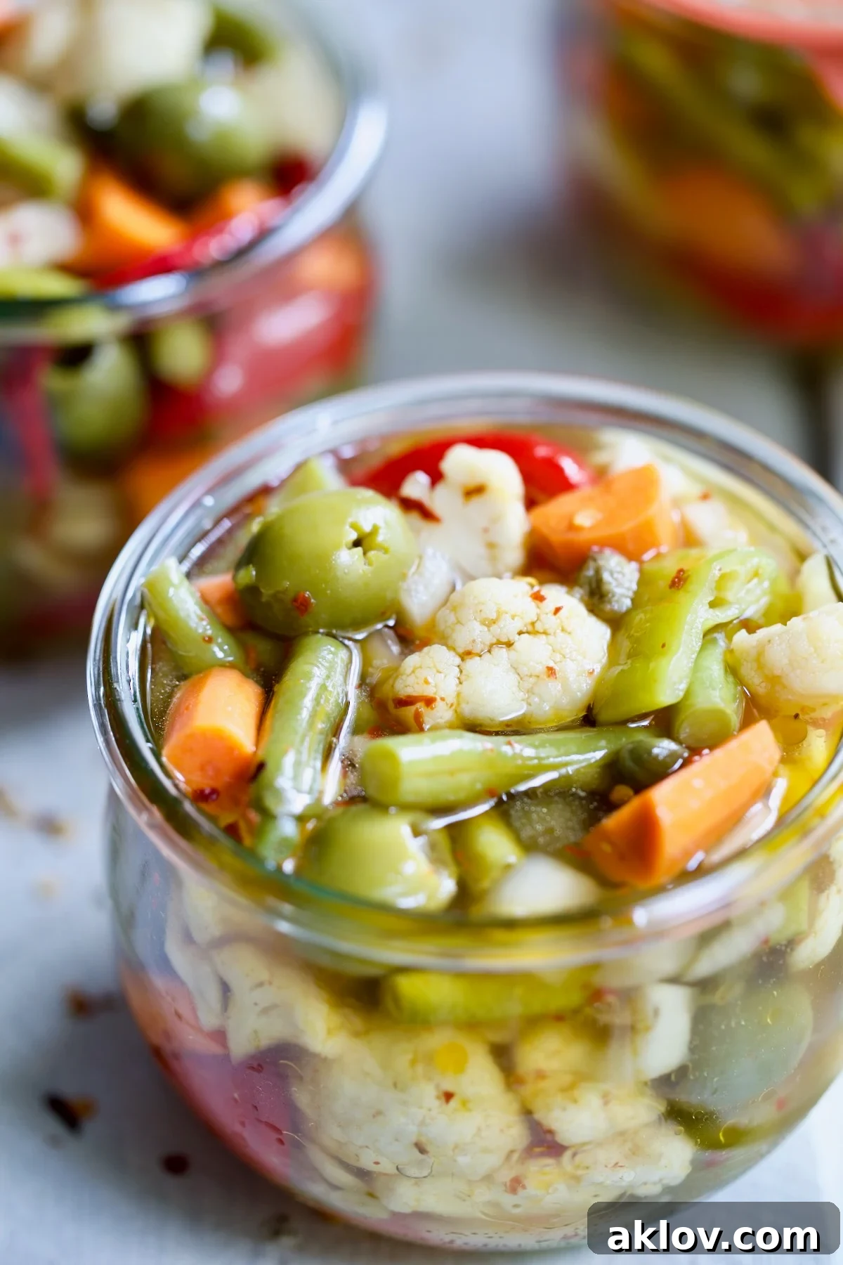 A beautifully arranged jar of vibrant homemade Giardiniera (Italian Pickled Vegetables), showcasing crisp, colorful vegetables submerged in a clear, flavorful brine.