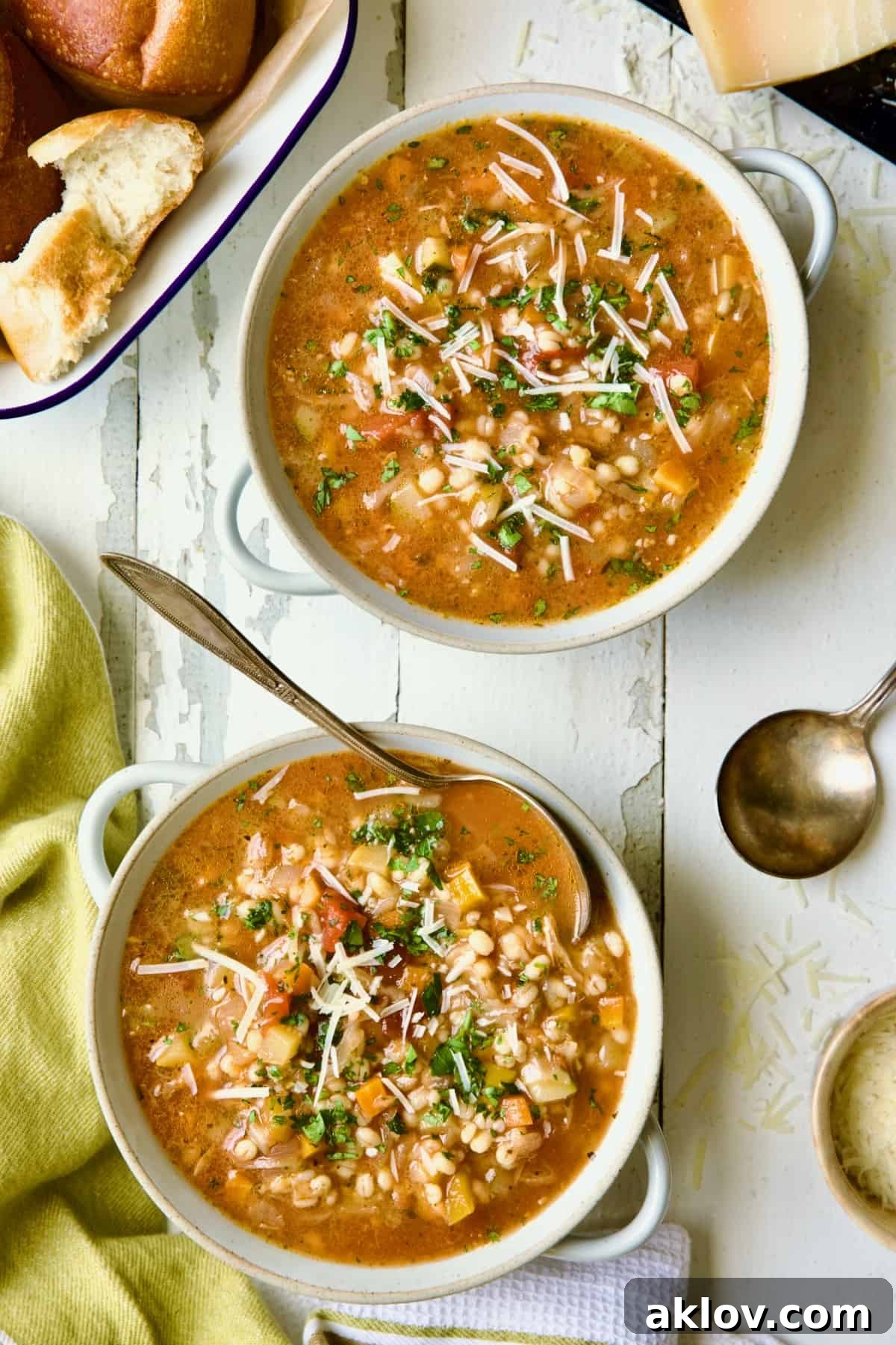 Two bowls of Vegetable Barley Soup on white distressed background.
