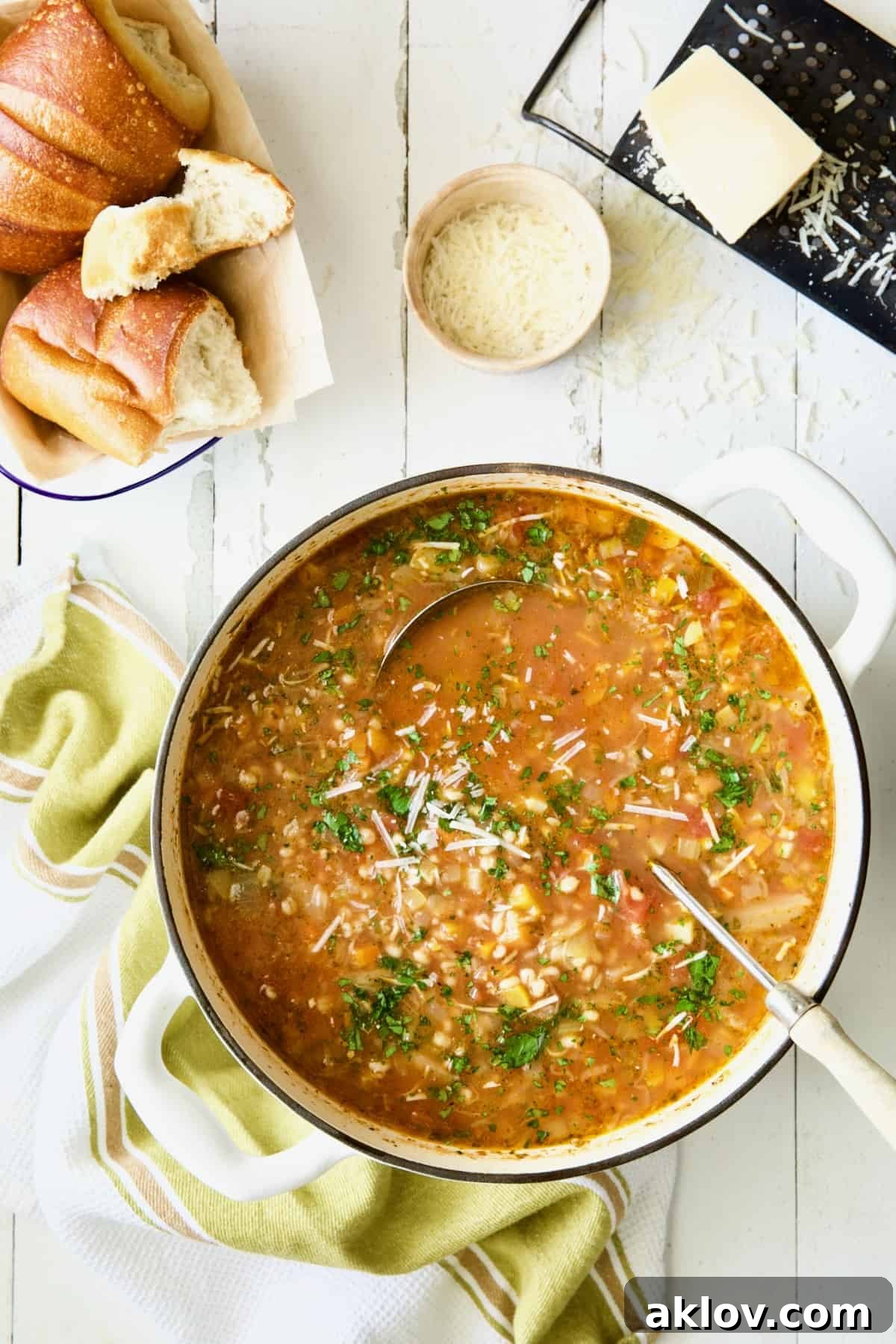 Pot of Vegetable Barley Soup on white distressed background.