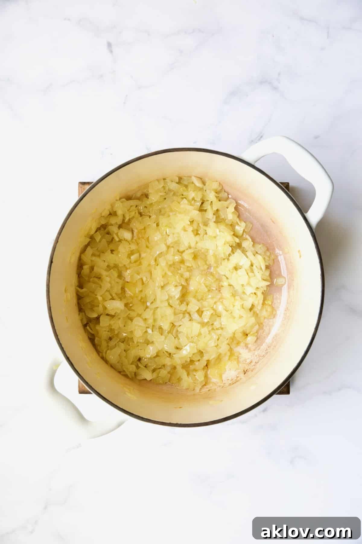 Cooked onions in white Dutch oven.