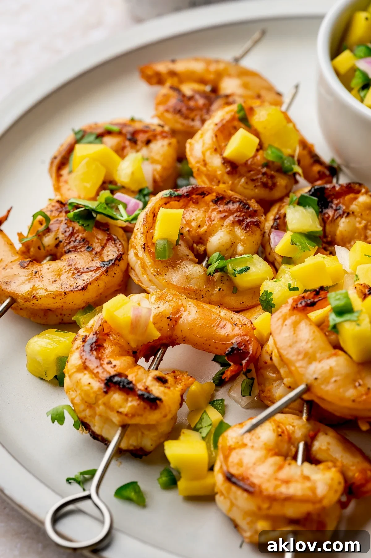Plated Grilled Shrimp Skewers with a side of refreshing Mango Pineapple Salsa, ready to be enjoyed.