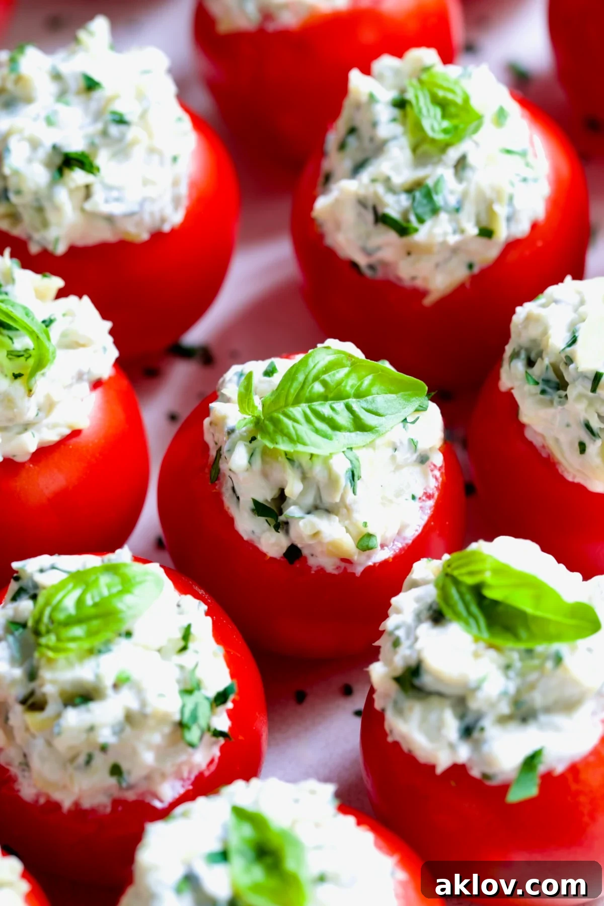 Cream Cheese and Artichoke Stuffed Tomatoes garnished with fresh basil leaves.