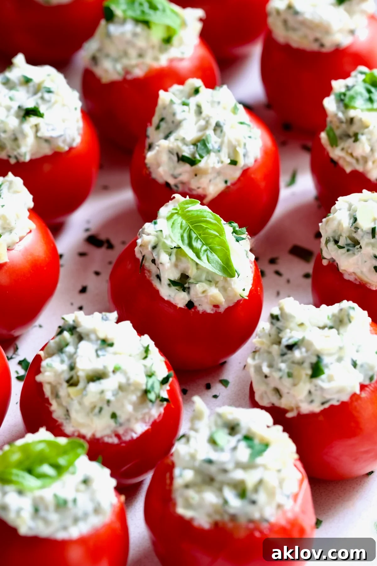 Cream Cheese and Artichoke Stuffed Tomatoes garnished with fresh basil leaves.