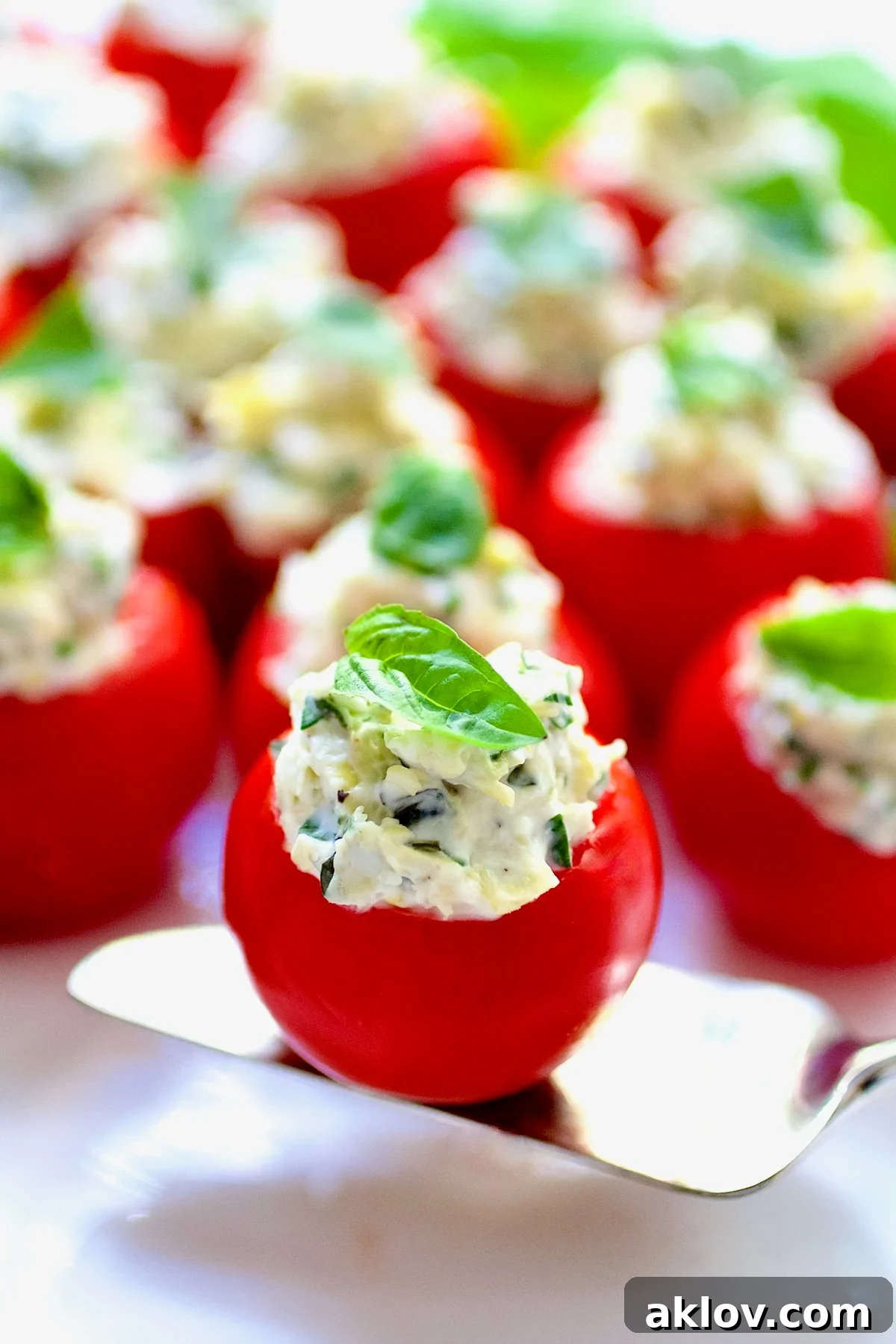 One Cream Cheese and Artichoke Stuffed Tomato on a small silver pie server.