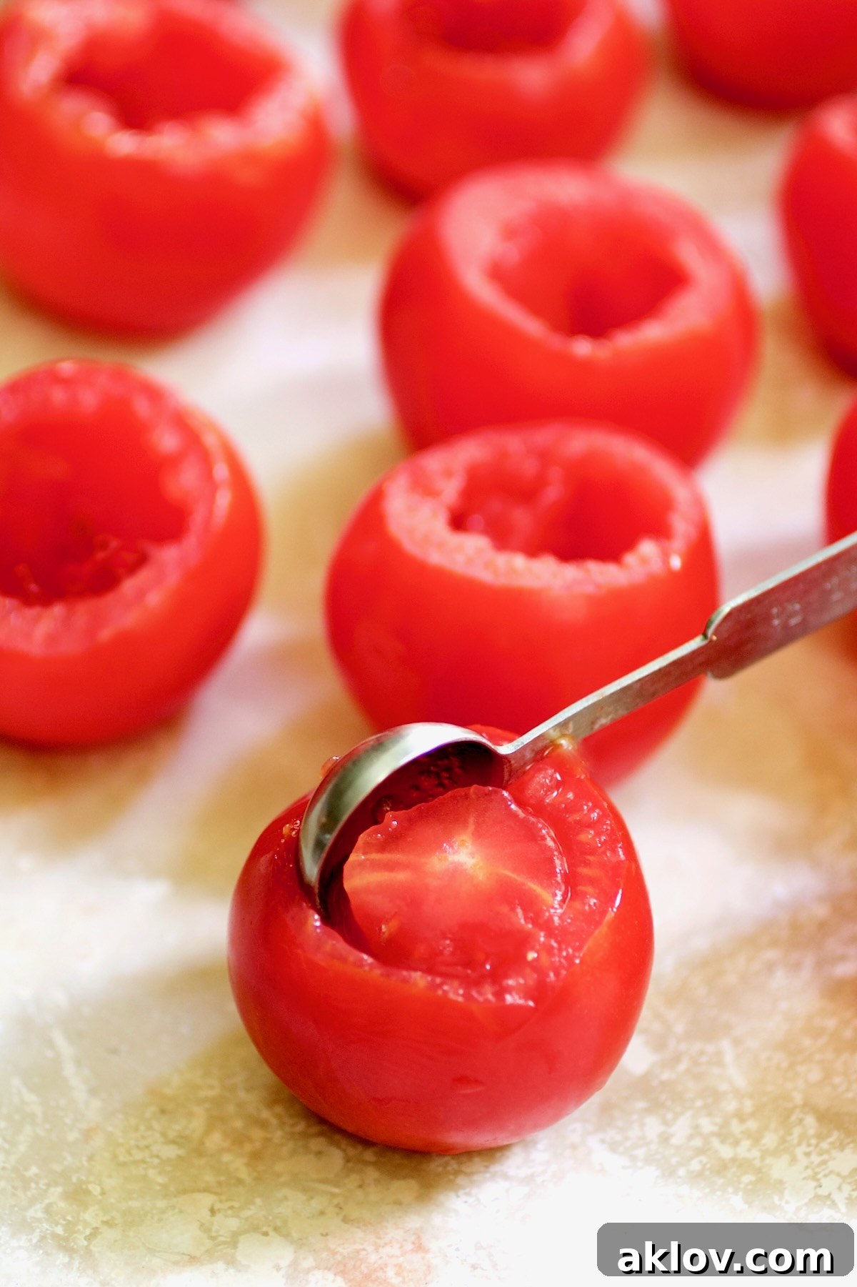 Teaspoon removing the center of Campari tomatoes.