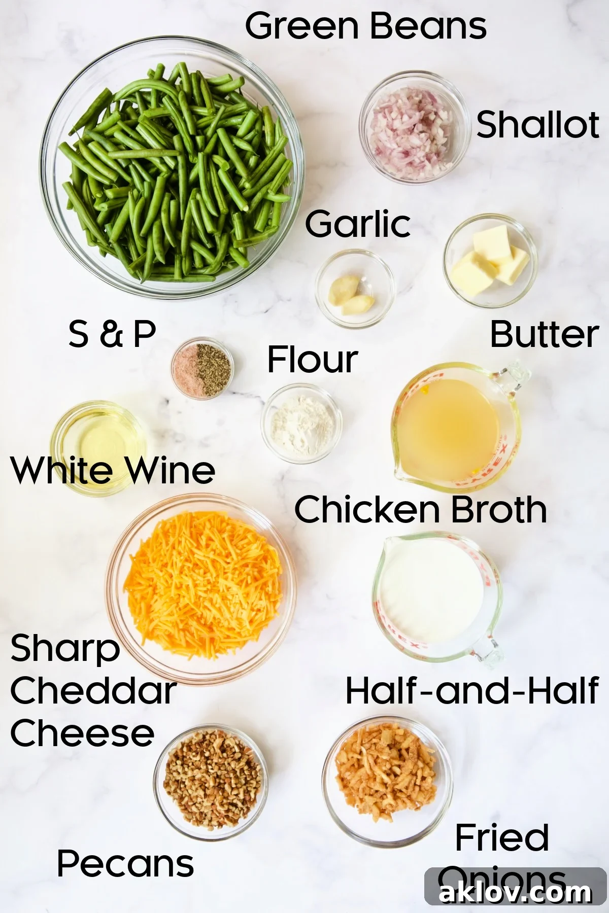 A collection of fresh ingredients arranged in glass bowls, including green beans, various spices, and cheese, ready for making the Cheesy Green Bean Casserole.