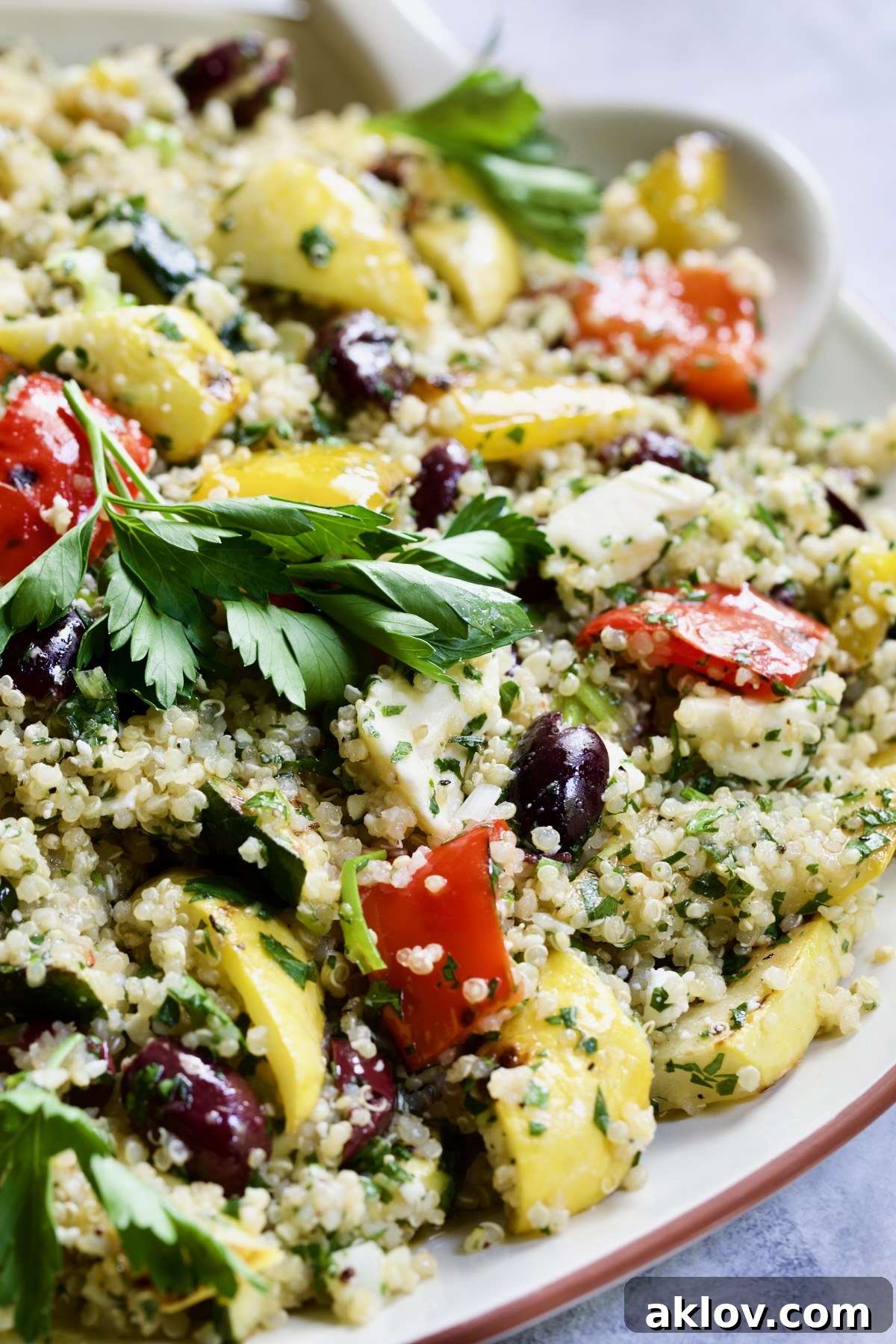Close-up of Mediterranean Quinoa Salad with Grilled Vegetables, showing the vibrant colors of fresh ingredients and garnished with delicate herb sprigs.
