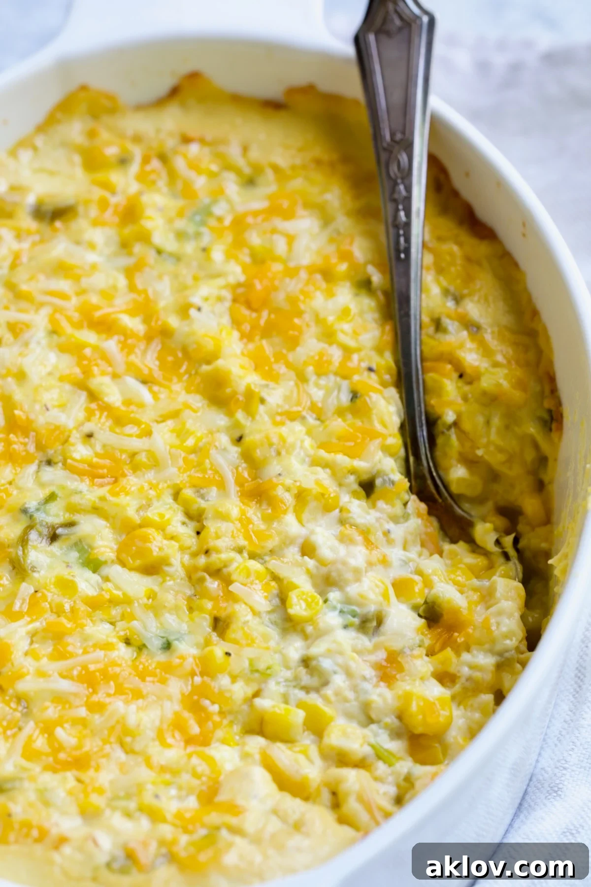 Cream Cheese Corn Casserole with Green Chiles in an elegant white oval baking dish, ready to serve.