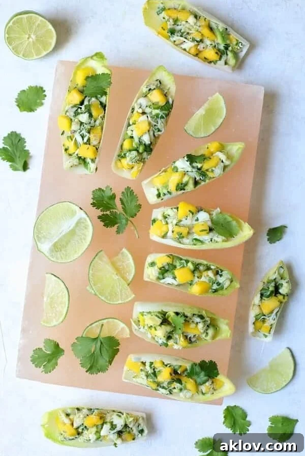 Crab Mango and Avocado Salad with Chile Lime Dressing in Endive - Overhead hero shot on pink salt block