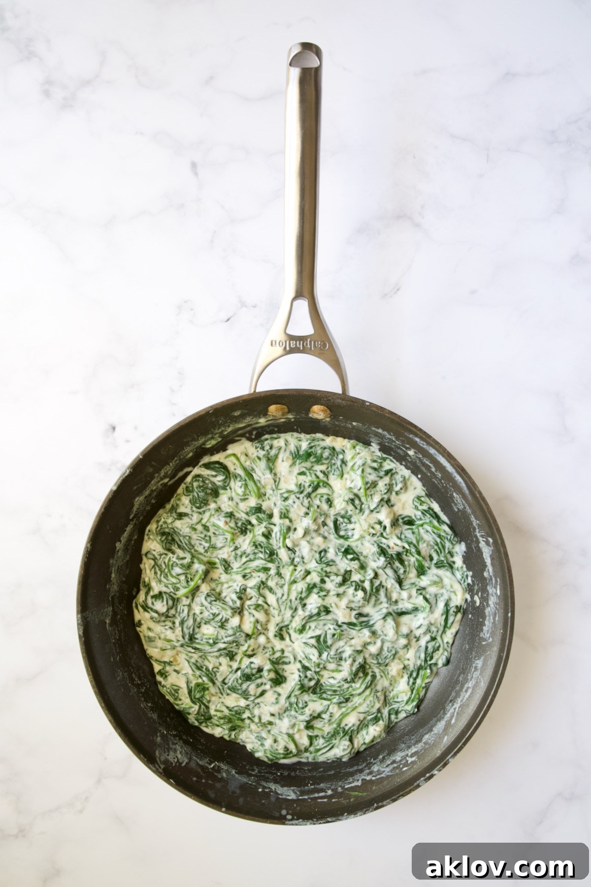 Completely incorporated wilted baby spinach in cheese sauce in a nonstick skillet.