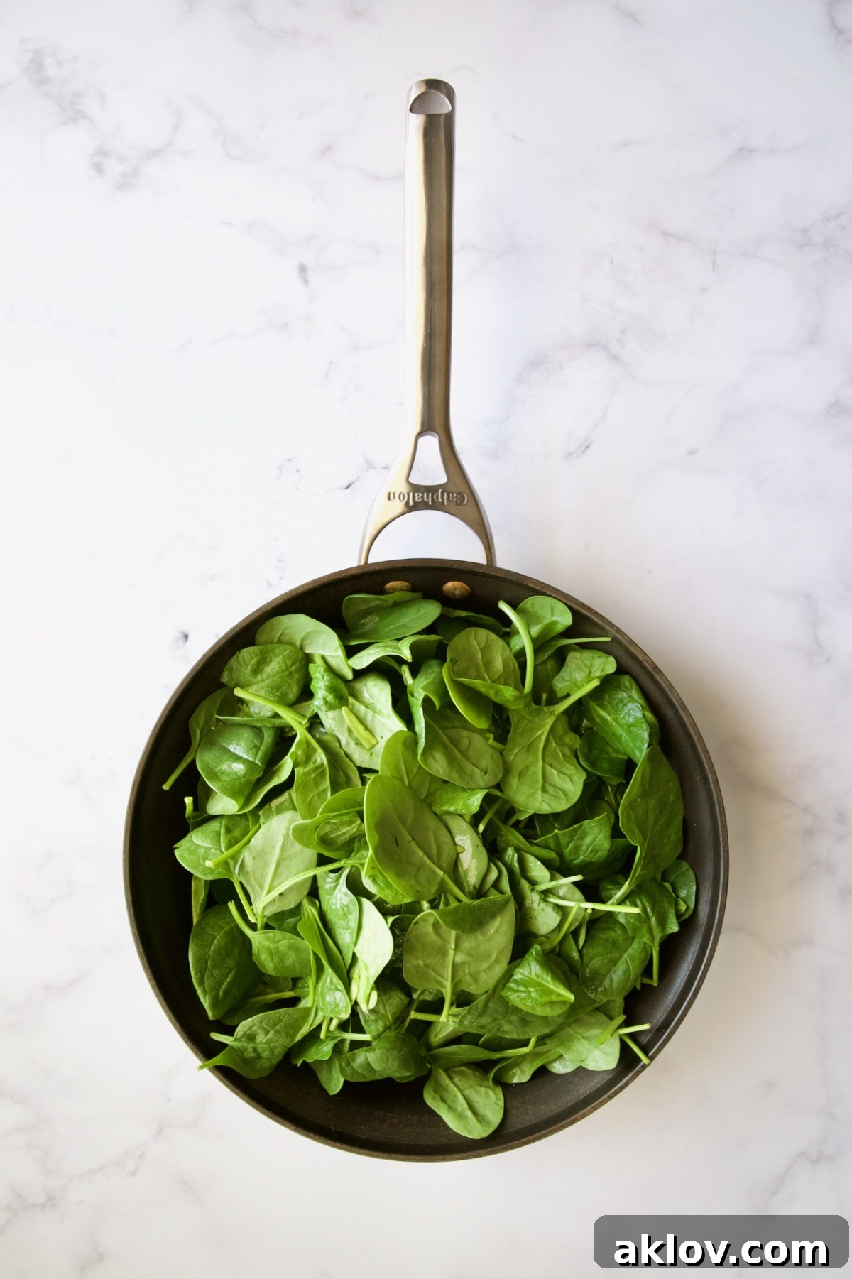 Fresh unwilted baby spinach in a nonstick skillet.