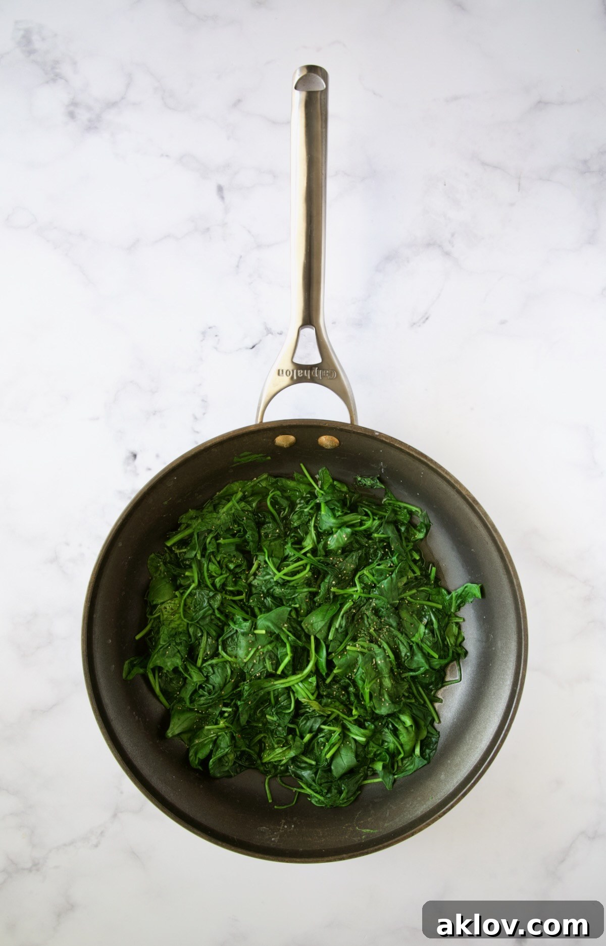 Wilted baby spinach in a nonstick skillet.