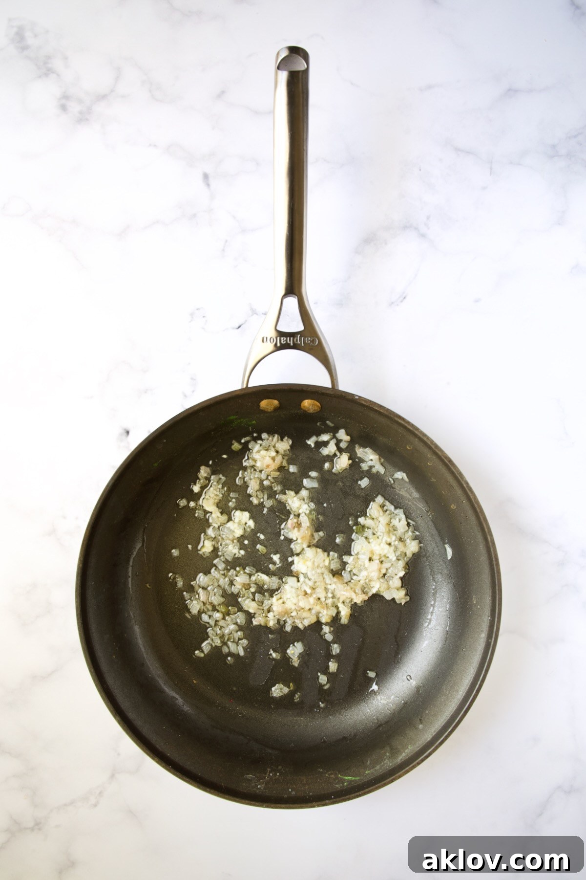 Sautéed shallots in butter within a nonstick skillet.