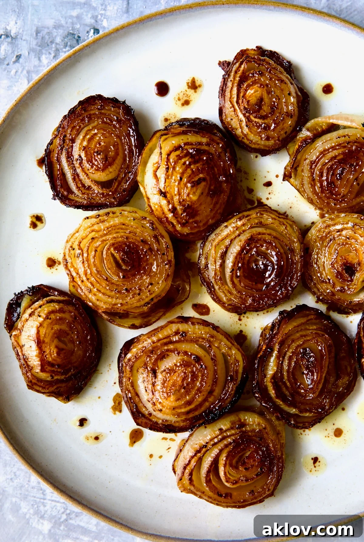 A final presentation of perfectly roasted onions on a round plate, garnished and ready for serving.