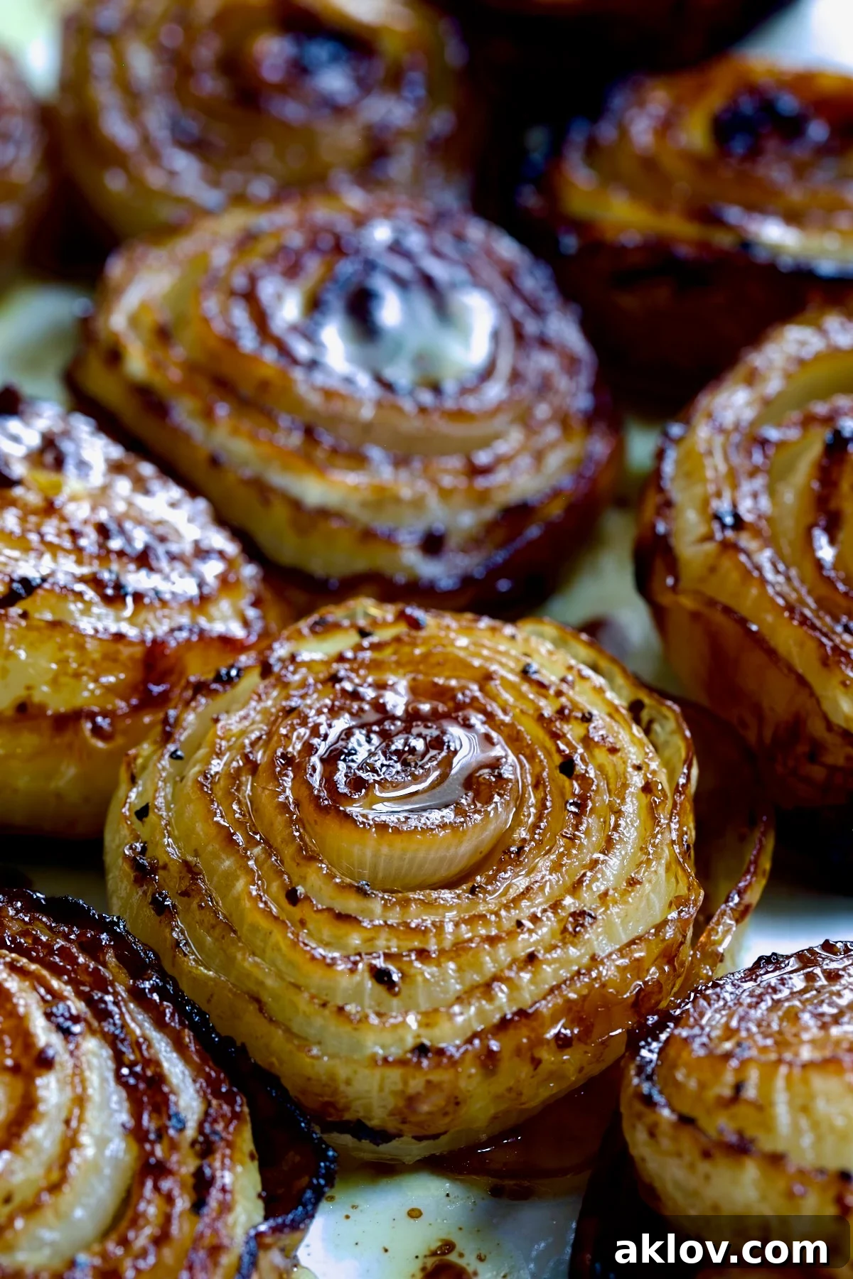 Close-up shot of several perfectly roasted onion halves, highlighting their golden-brown caramelization and tender layers.
