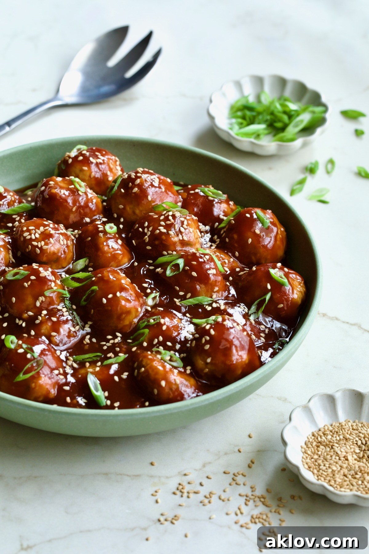 A close-up side view of Asian Chicken Meatballs, garnished and ready to serve.