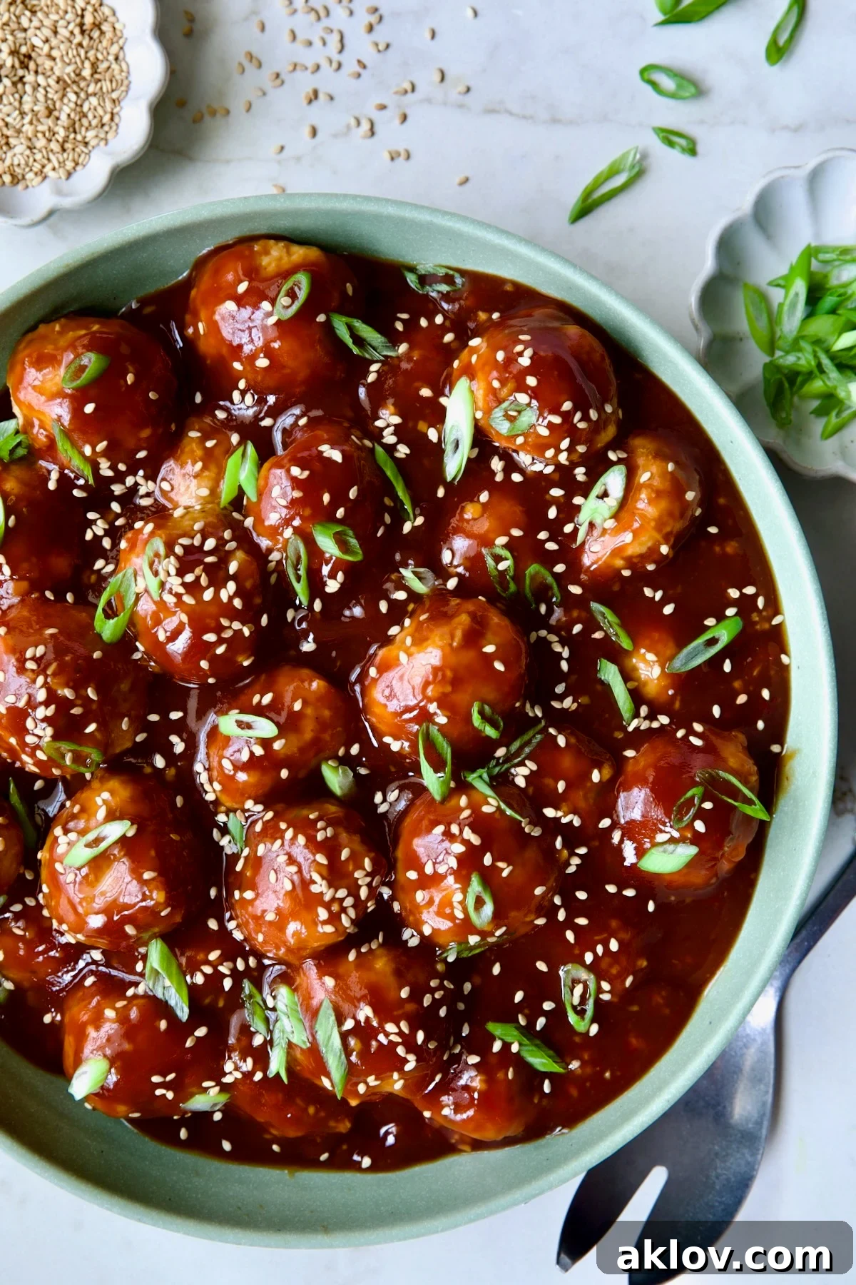 A smaller portion of Asian Chicken Meatballs in a green bowl, ready for serving or storage.