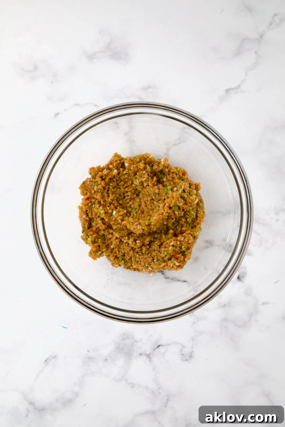 Meatball ingredients in a glass bowl before adding ground chicken.