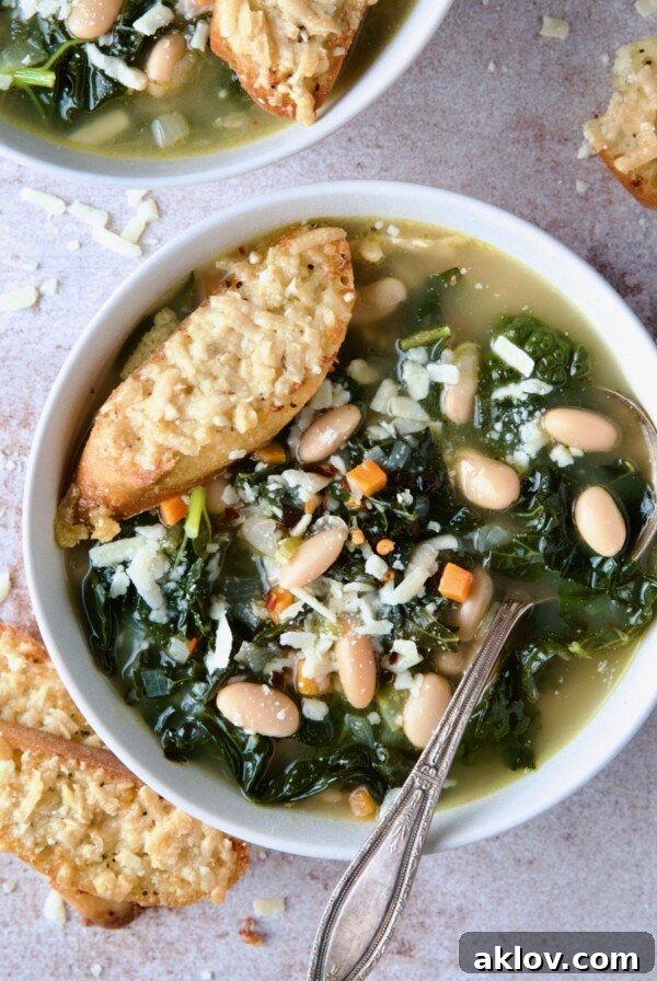 A single bowl of comforting White Bean Kale Soup, accompanied by a golden Parmesan Toast, epitomizing rustic wholesome dining.