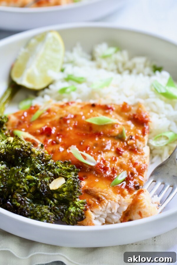 Sheet Pan Thai Baked Fish with Broccolini on white plate with fork.