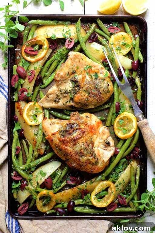 Sheet Pan Roast Chicken with Potatoes Green Beans Olives and Lemon on baking sheet with meat fork.