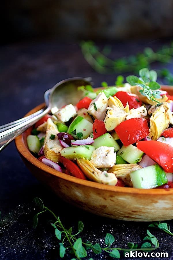 Photo of Greek Vegetable Salad with Marinated Feta Cheese in wood bowl on dark blue background/