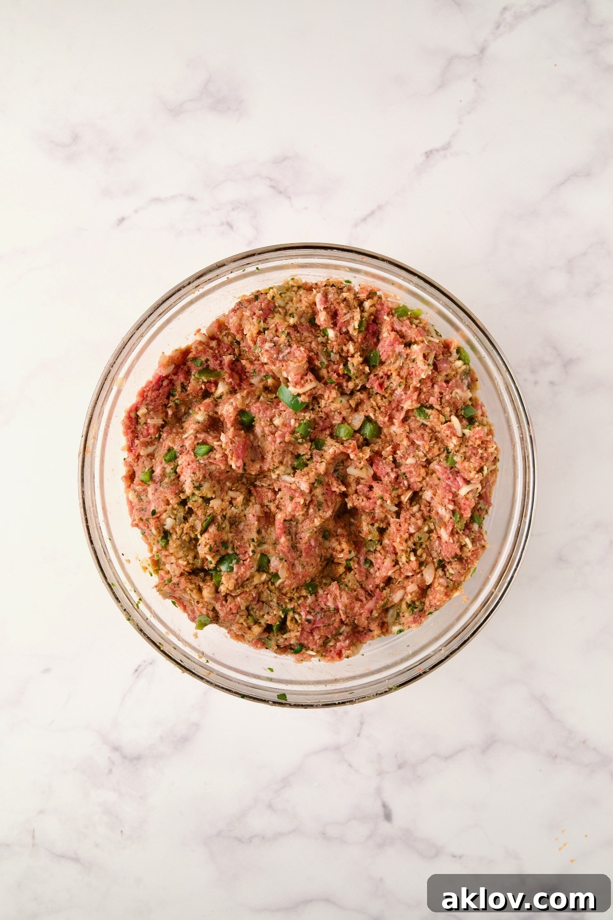 Ingredients for meatloaf fully combined in a glass bowl before being placed on sheet pan.