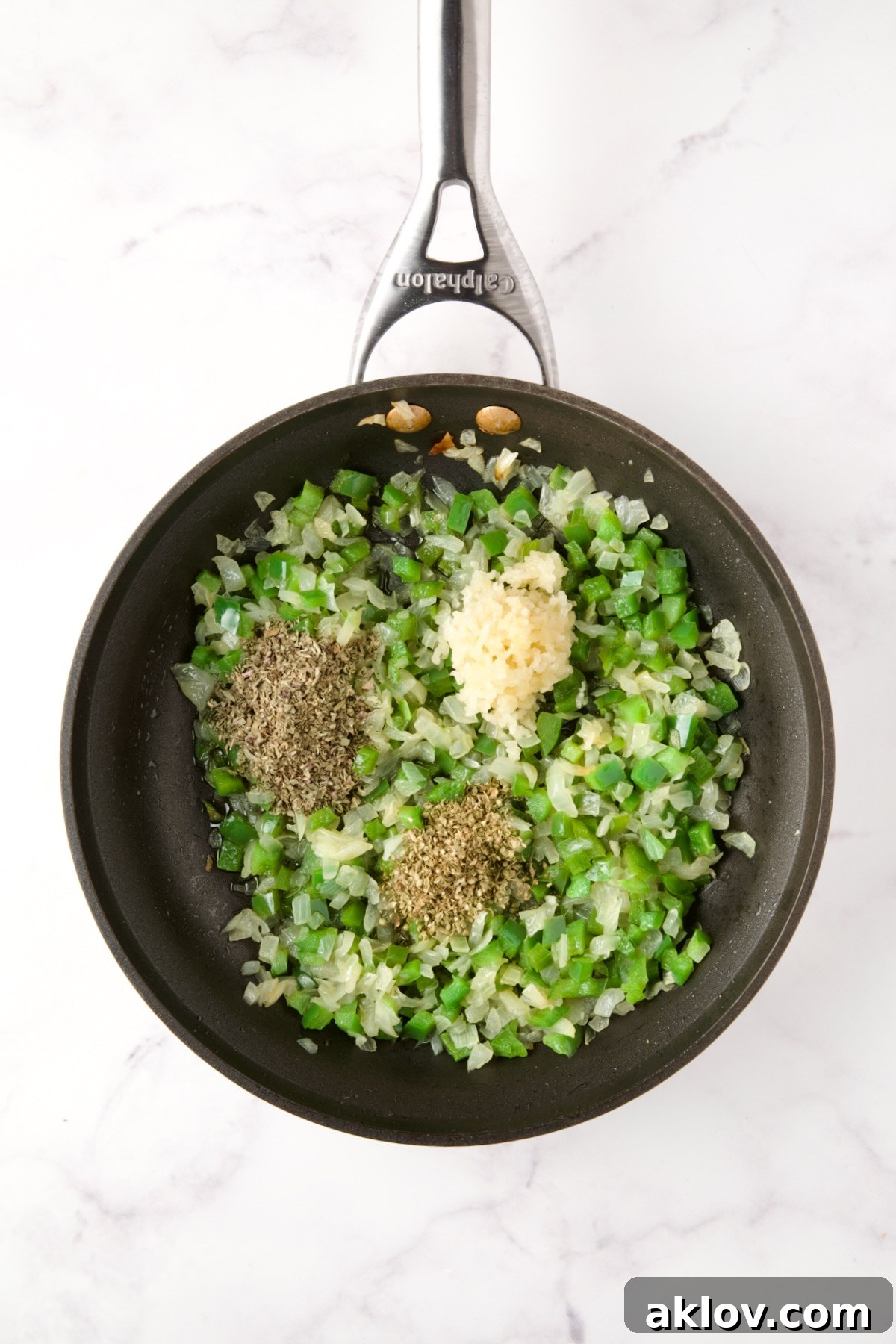 Cooked onions and green peppers in a nonstick skillet with dried herbs and garlic added.
