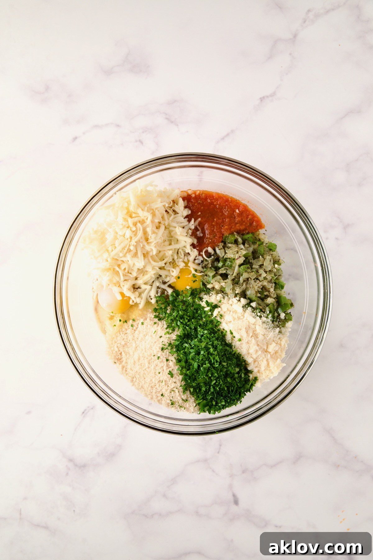 Ingredients for meatloaf in a glass bowl before being mixed together.
