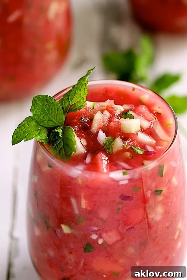 Watermelon Gazpacho with Serrano Chiles and Mint - Close-up shot of gazpacho in glass garnished with fresh mint