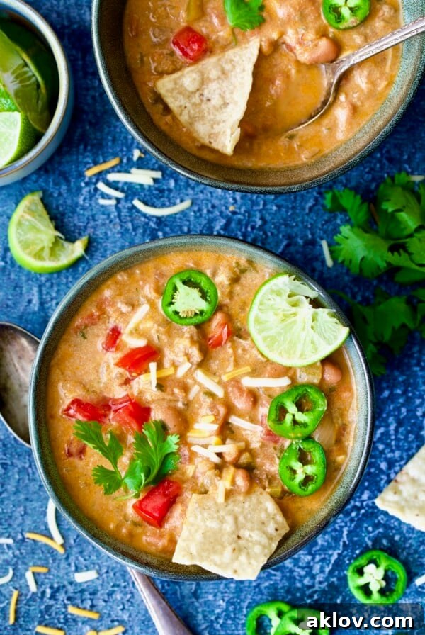 Creamy Taco Soup garnished with diced tomatoes, sliced jalapenos and tortilla chips, a hearty, zesty, and easy weeknight meal.