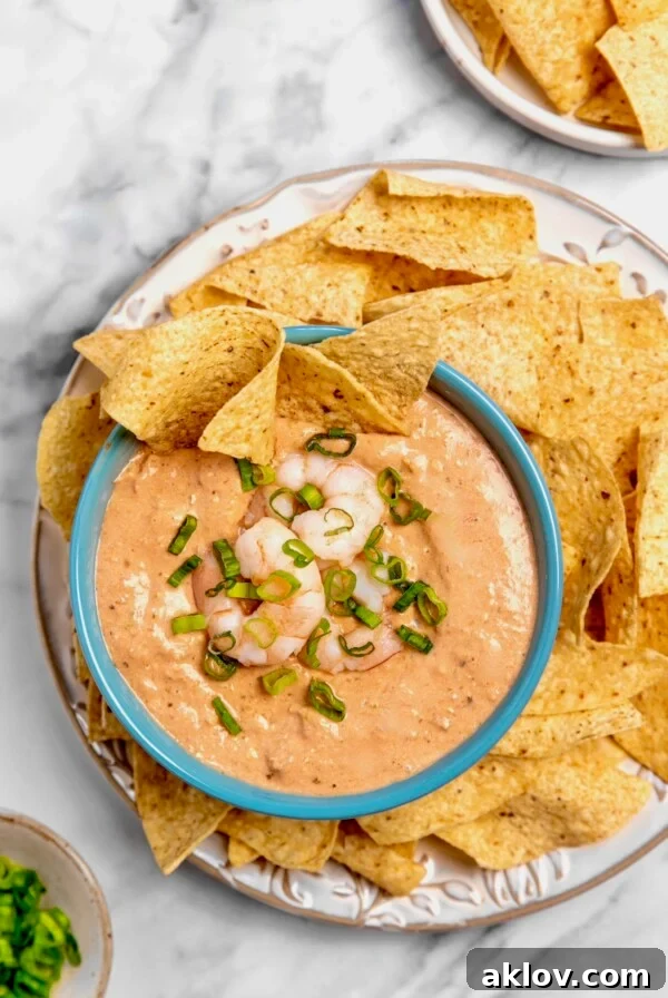Creamy Shrimp Salsa Dip in bright blue bowl on platter with tortilla chips, a super easy and delicious appetizer.
