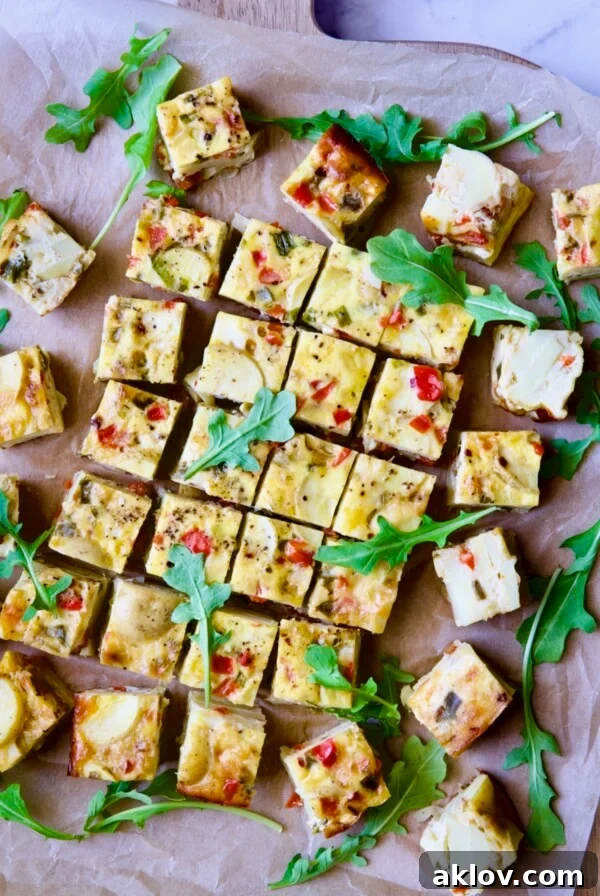 Oven-Baked Spanish Tortilla on cutting board garnished with arugula, a hearty and flavorful dish.