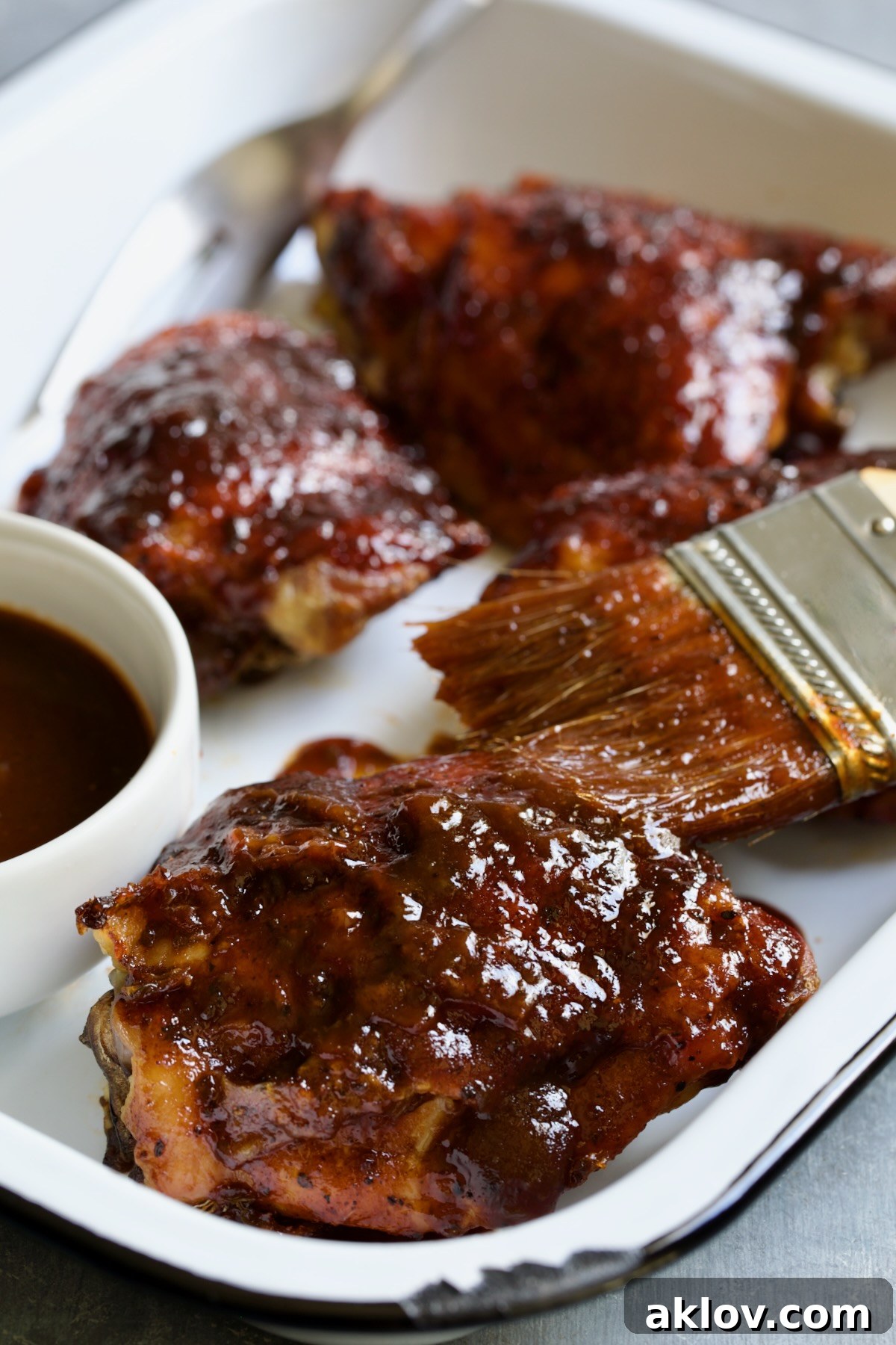 Baked BBQ Chicken Thighs in white enamel serving tray.