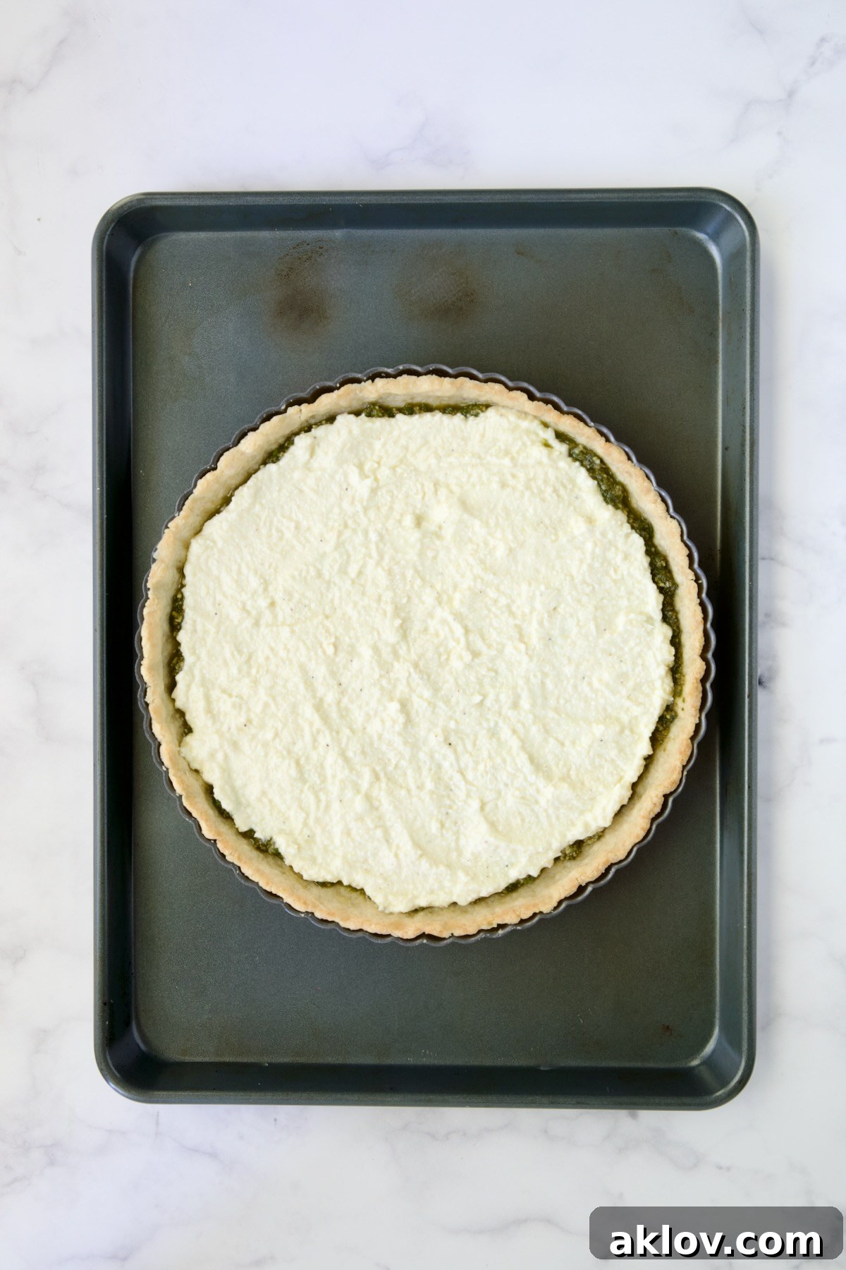 Ricotta custard layer added over pesto.