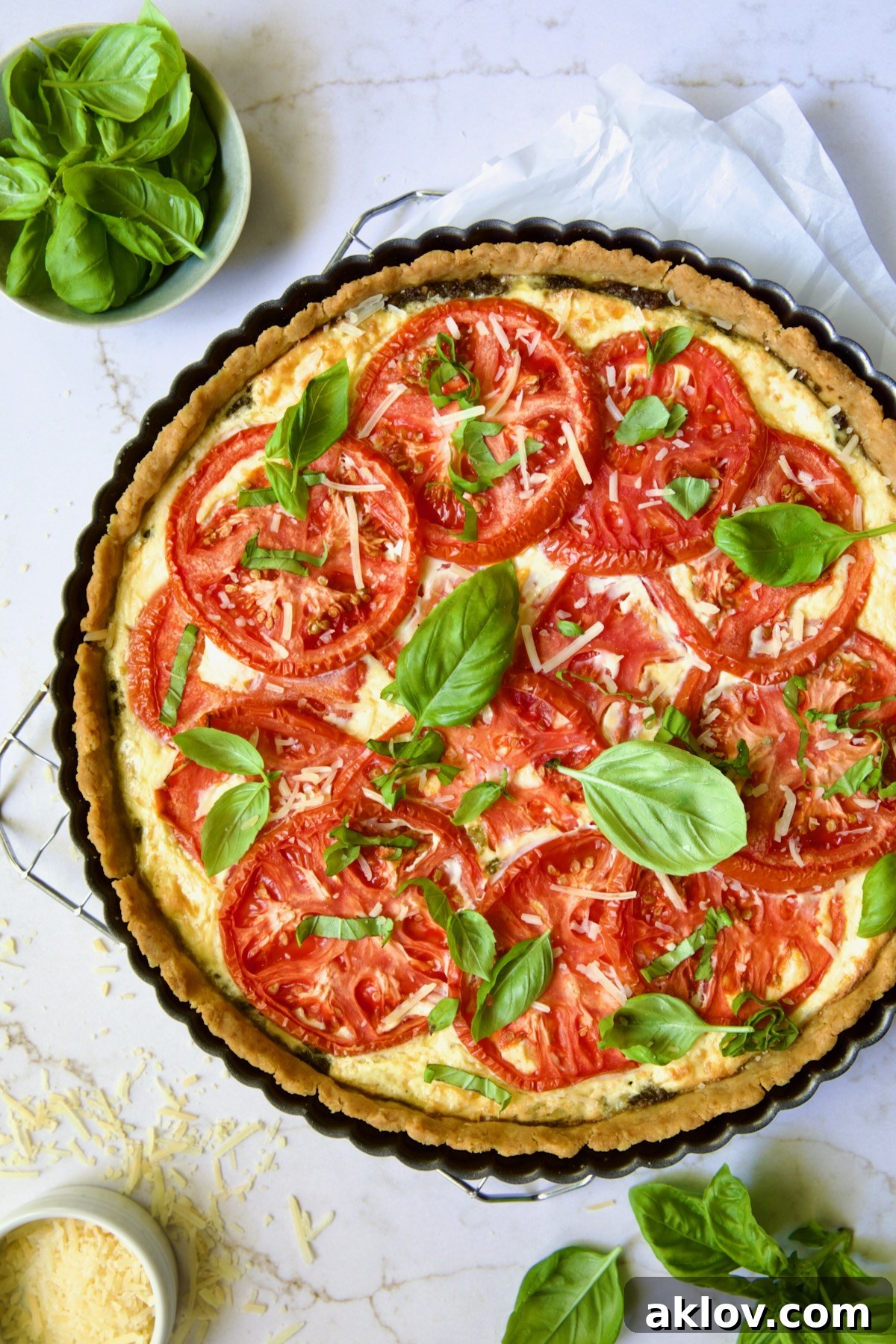 Whole Tomato Tart with Ricotta and Cheese on cooling rack garnished with fresh basil leaves.